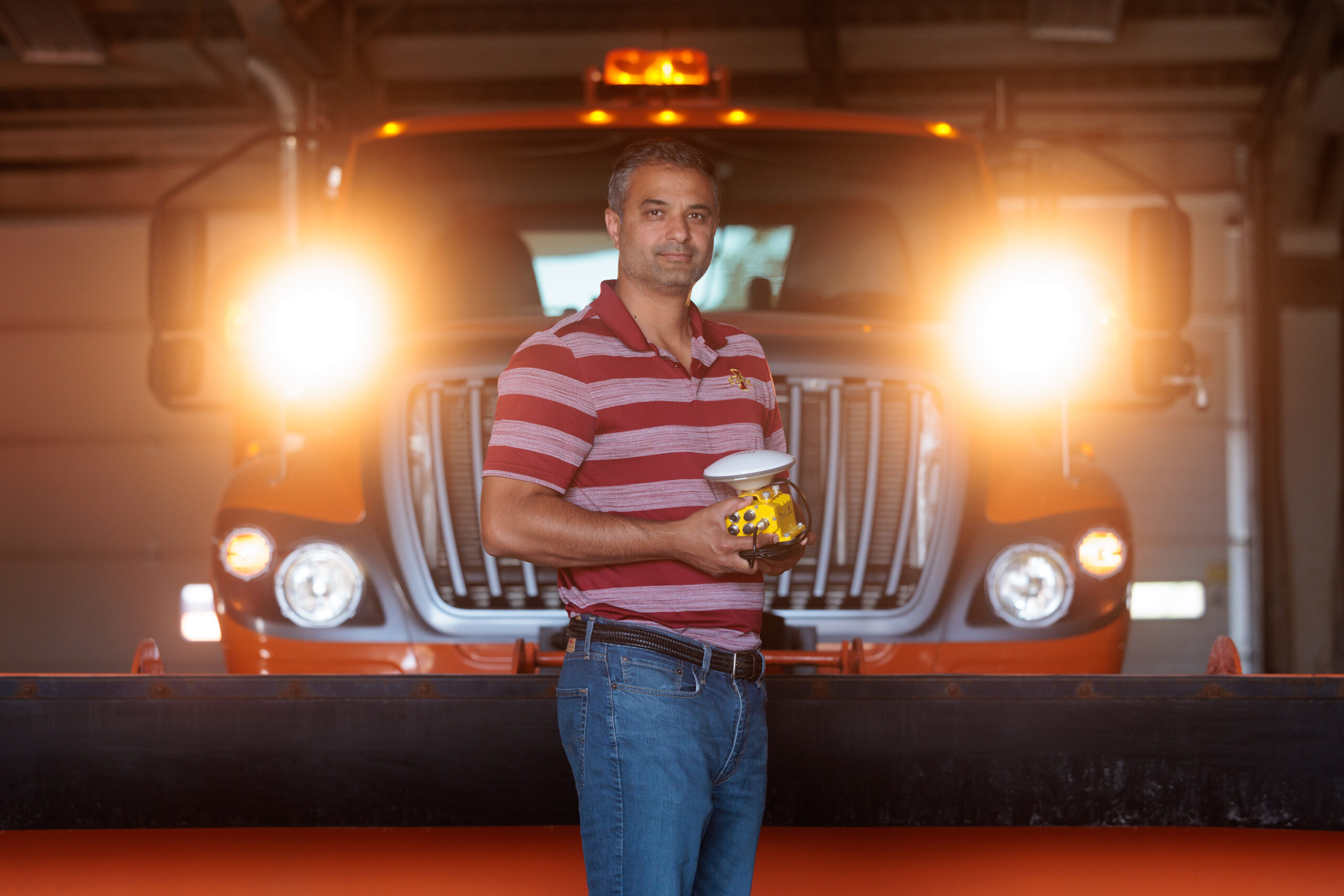 Anuj Sharma poses in front of snowplow